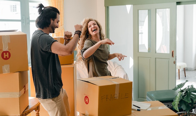 two people laughing while unpacking boxes