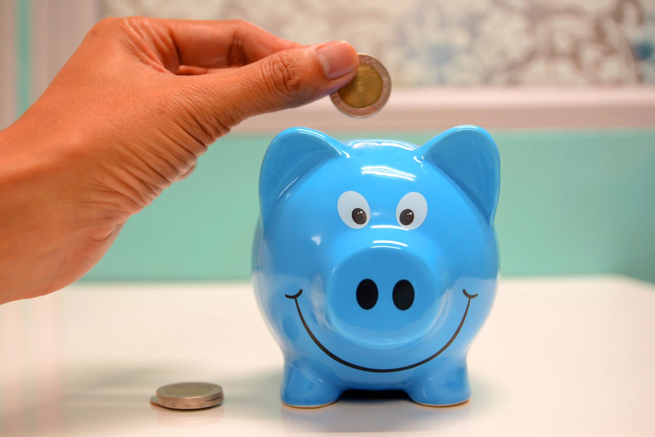 coin being dropped into blue piggy bank
